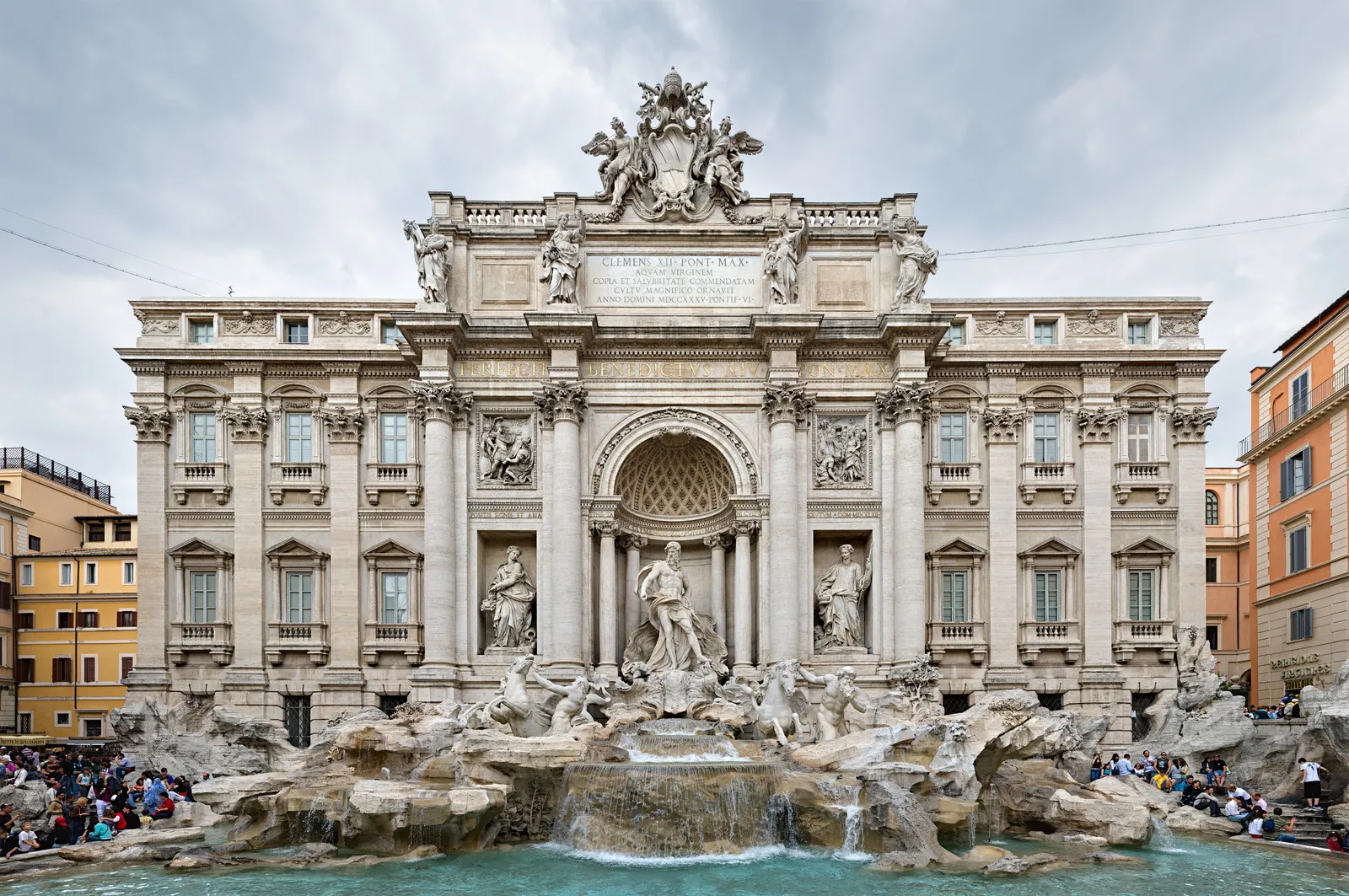 The Trevi Fountain in Rome, its baroque facade and sculpted figures visible in daylight