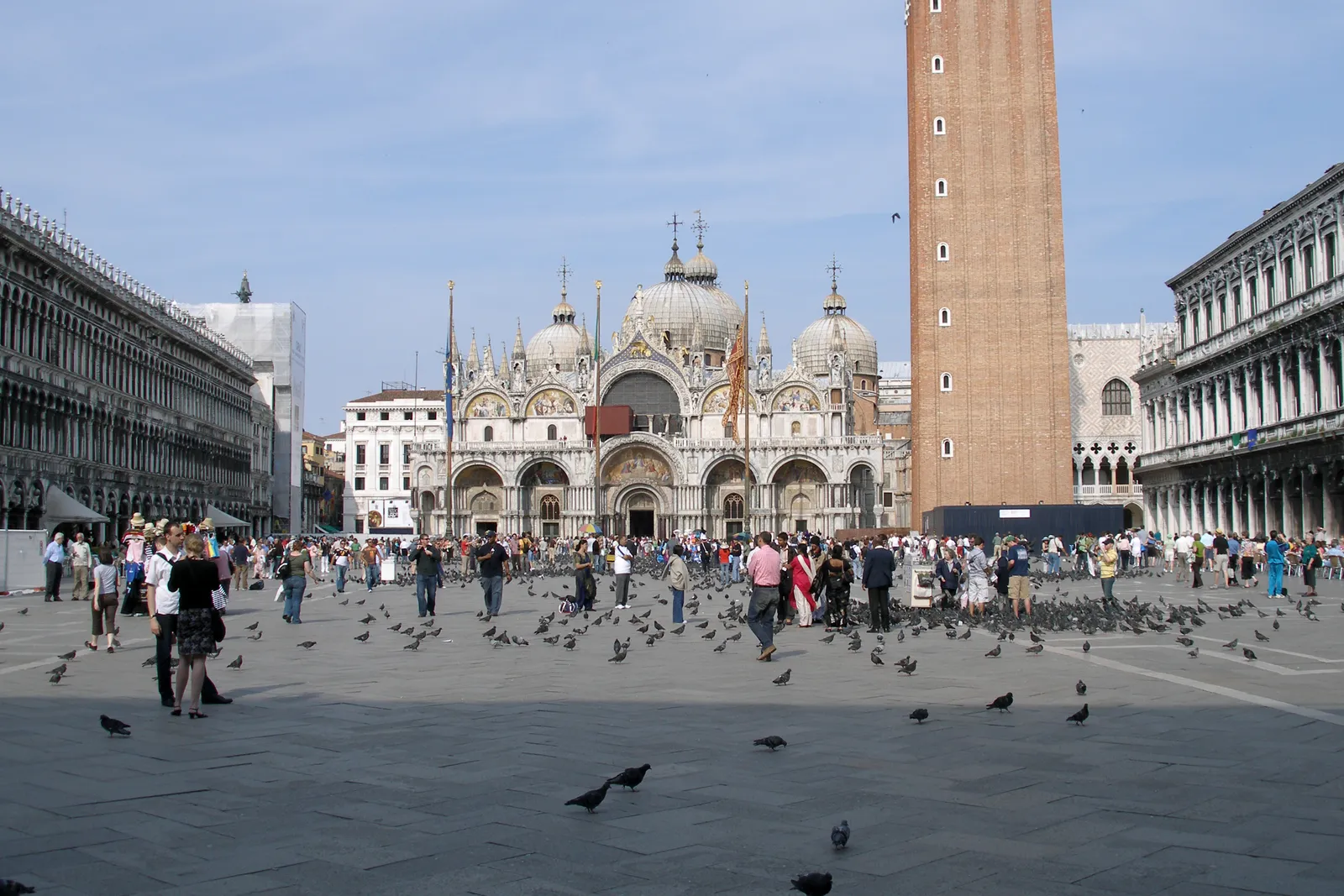 St. Mark's Square in Venice with the domed Basilica facade, the campanile bell tower, and crowds in the piazza