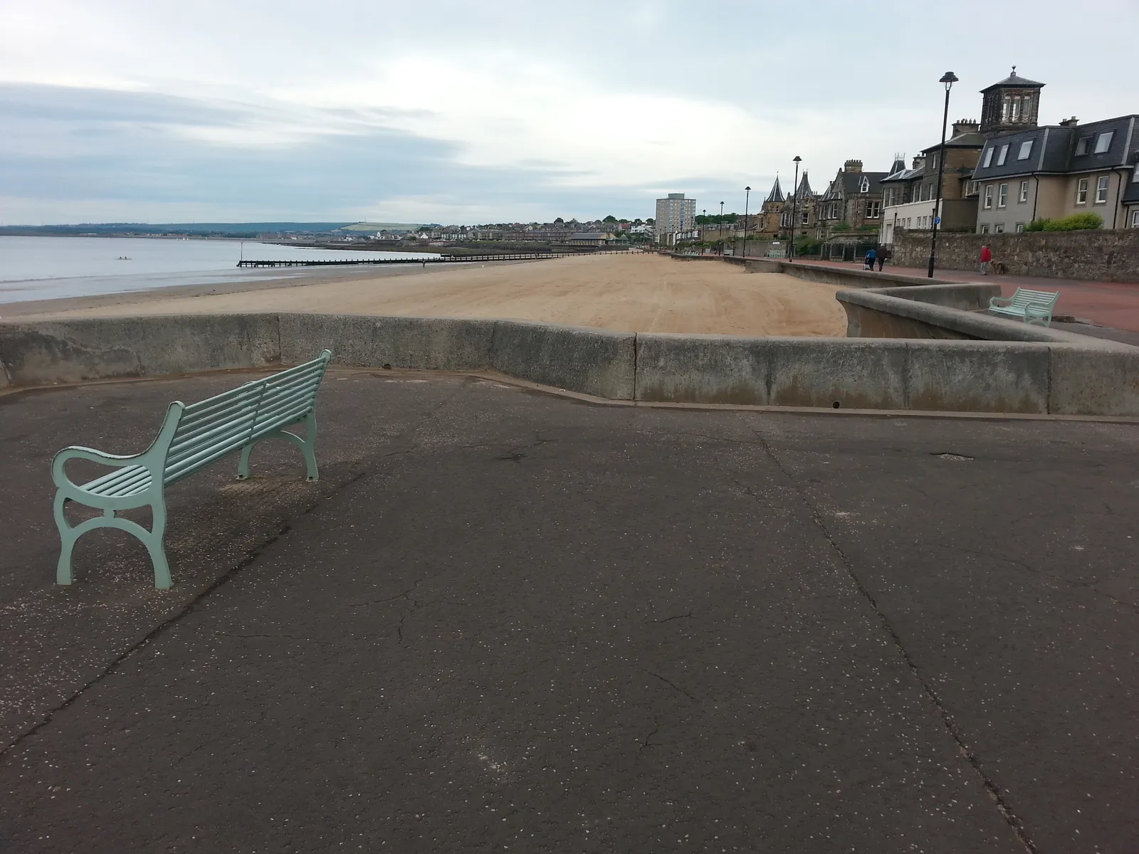The sandy beach and promenade at Portobello, Edinburgh, with a bench overlooking the sand and Victorian buildings along the seafront