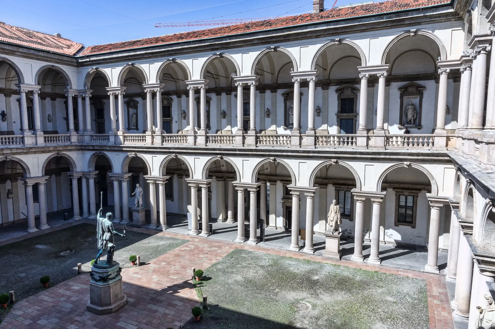 The Renaissance colonnaded courtyard of the Pinacoteca di Brera in Milan, lined with classical statues