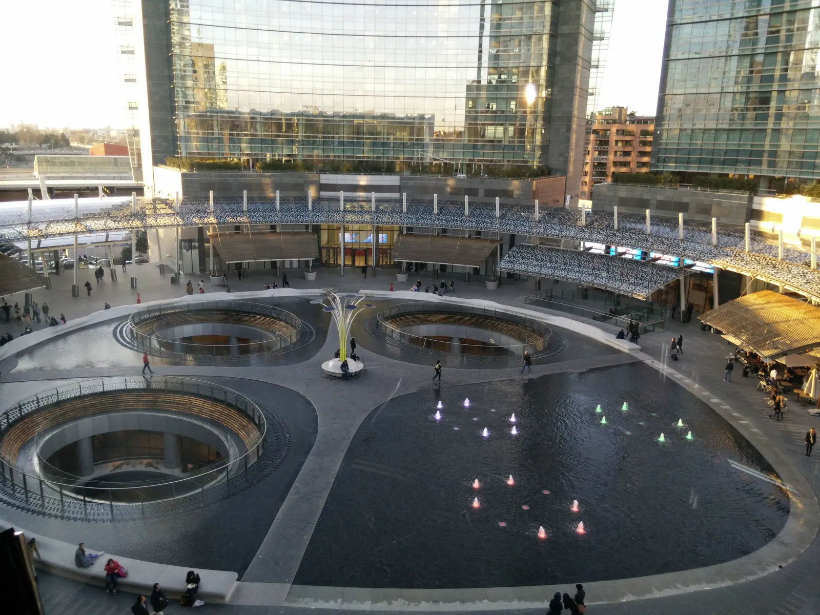 Piazza Gae Aulenti in Milan, a raised circular plaza with fountains surrounded by glass office towers