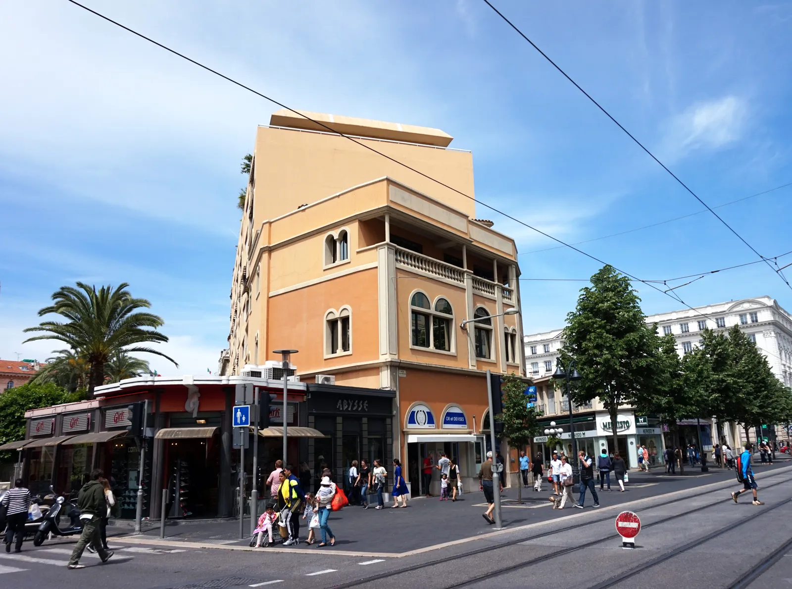 Avenue Jean Médecin in Nice, a pedestrian shopping street with tram wires overhead and palm trees along the sidewalk